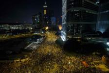 Thousands of protesters attend a rally outside the government headquarters in Hong Kong as riot police stand guard